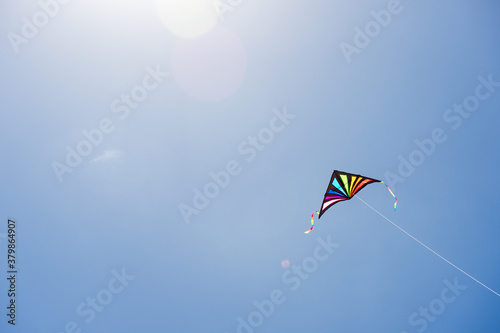 Colorful kite flying against a blue sky photo