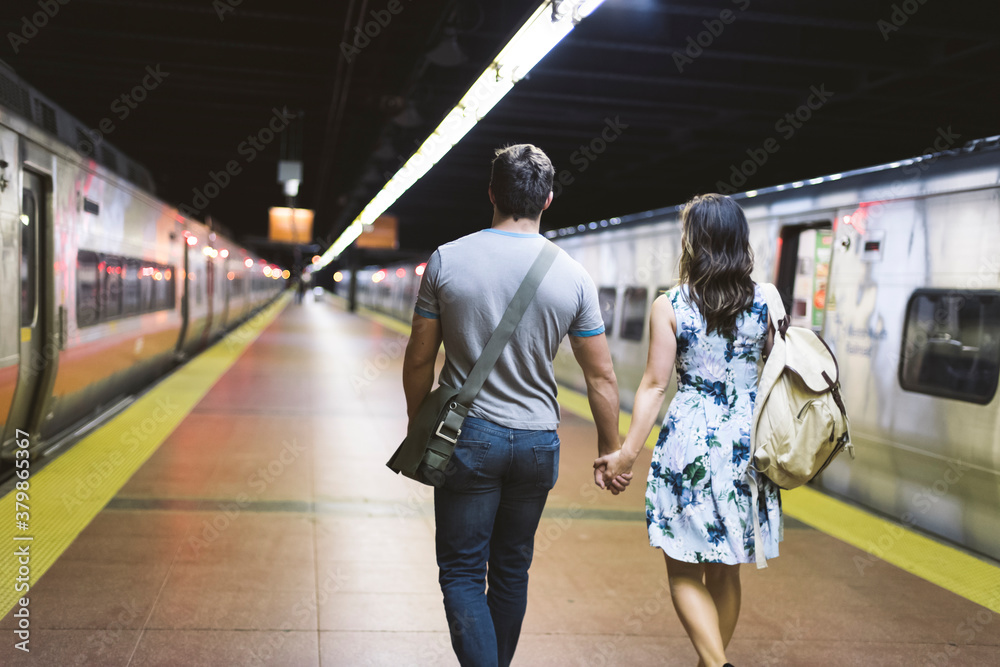 Young couple walking hand in hand in the station Young couple walking hand in hand in the station