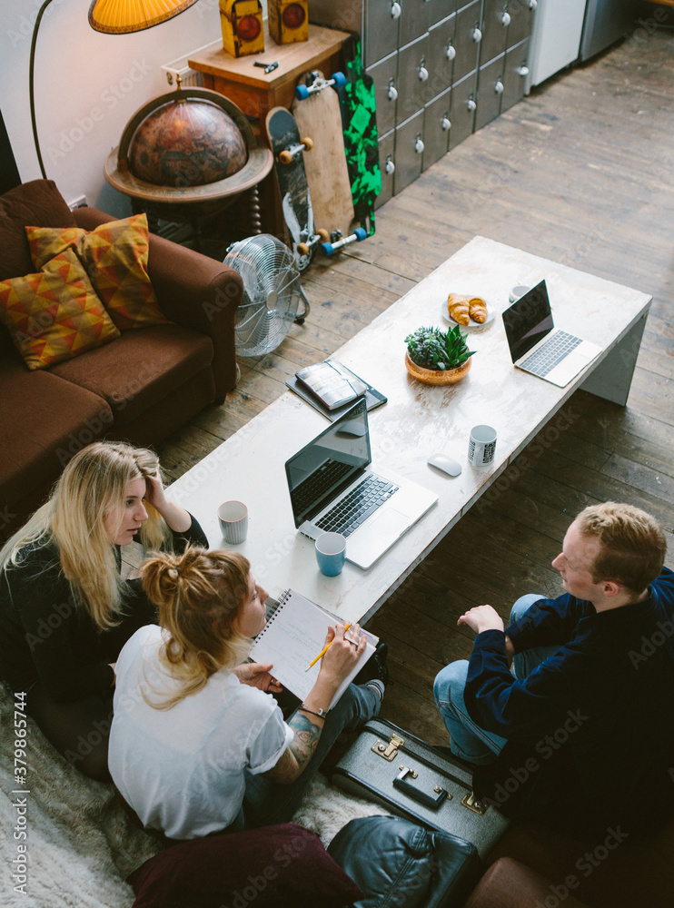 Three young business people discussing on a sofa Three young business people discussing on a sofa