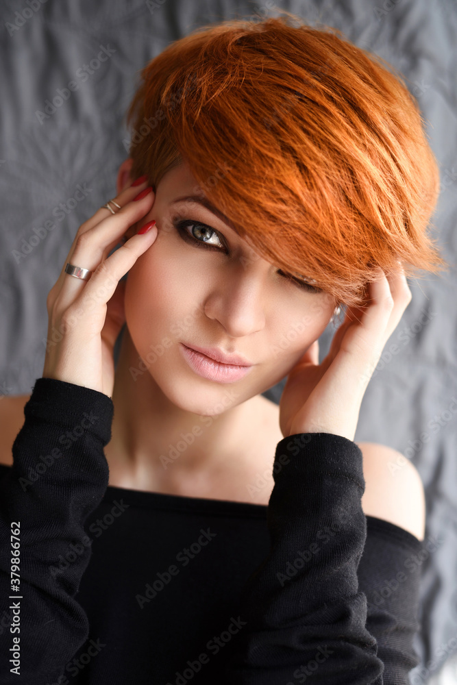 Obraz premium Portrait of a beautiful young red-haired woman with short hair