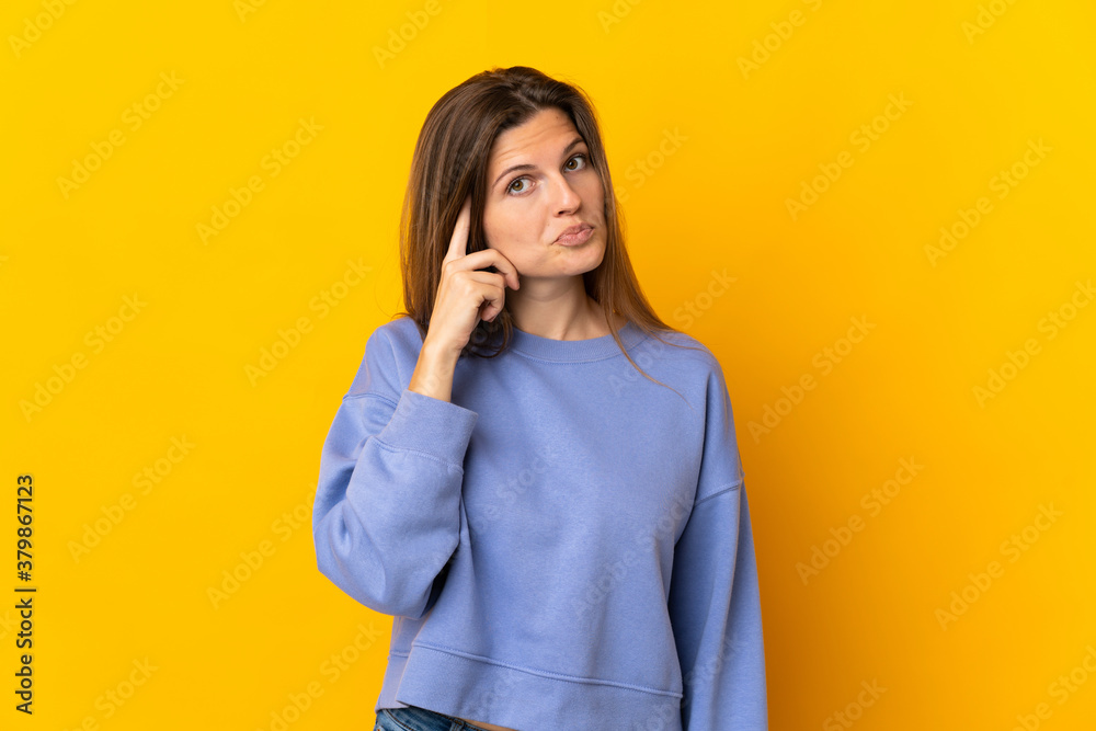 Young Slovak woman isolated on yellow background thinking an idea Young Slovak woman isolated on yellow background thinking an idea