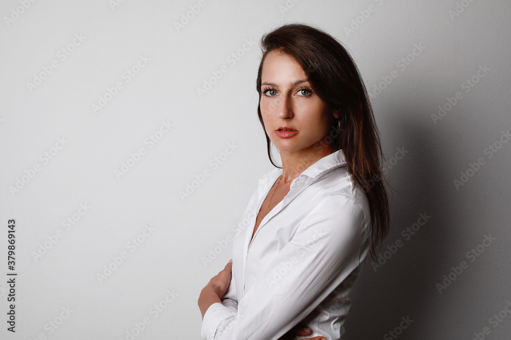 Close-up portrait of young business woman with serious face expression posing isolated over grey wall background. Close-up portrait of young business woman with serious face expression posing isolated over grey wall background.