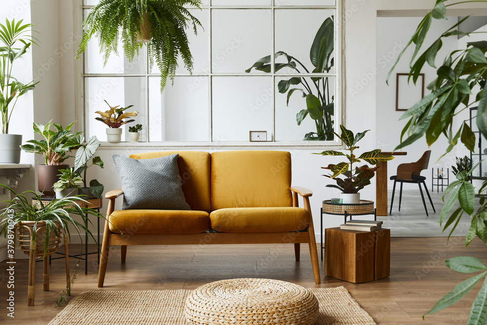 Interior design of scandinavian open space with yellow velvet sofa, plants, furniture, book, wooden cube and personal accessories in stylish home staging. Template.