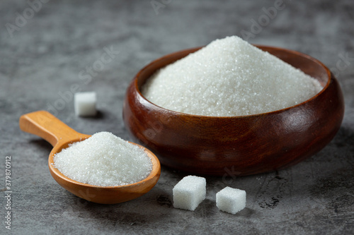 World diabetes day; sugar in wooden bowl on dark background