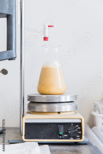 Glass container with beer sample on a magnetic stirrer in lab