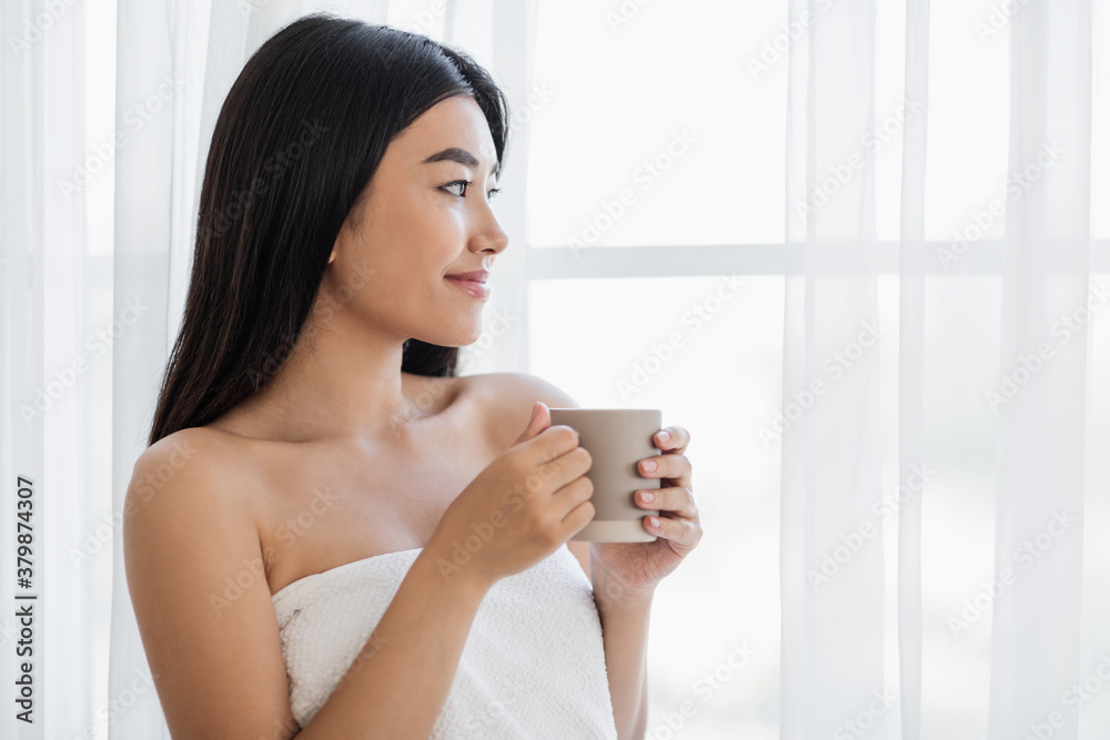 Dreamy woman with cup of morning coffee looking through window Dreamy woman with cup of morning coffee looking through window
