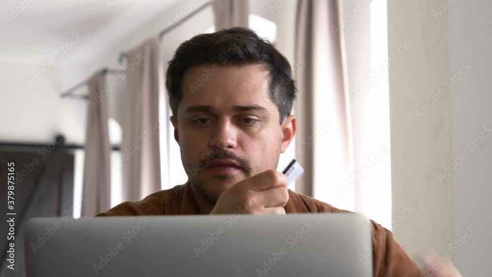 Guy with notebook and credit card doubt about shopping online Guy with notebook and credit card doubt about shopping online