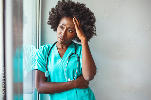 Quadro em tela Shot of a young female nurse looking stressed out while standing at a window in a hospital