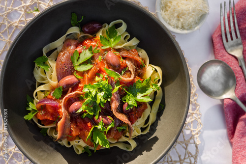 puttanesca fettuccine pasta in the afternoon light photo