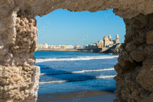 View at Cádiz, old historical town, through stone window in ruined wall, Andalusia, Spain.