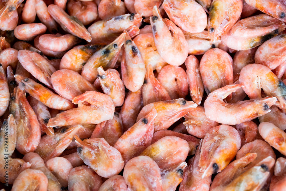 Close-up of a pile of frozen pink shrimps. Natural pink seafood background Close-up of a pile of frozen pink shrimps. Natural pink seafood background