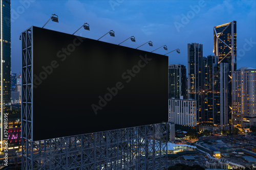 Blank black road billboard with KL cityscape background at night time. Street advertising poster, mock up, 3D rendering. Side view. The concept of marketing communication to promote or sell idea. © VideoFlow