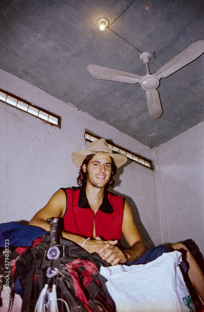Smiling Male Backpacker in Shabby Hotel Room Shot on Film Smiling Male Backpacker in Shabby Hotel Room Shot on Film