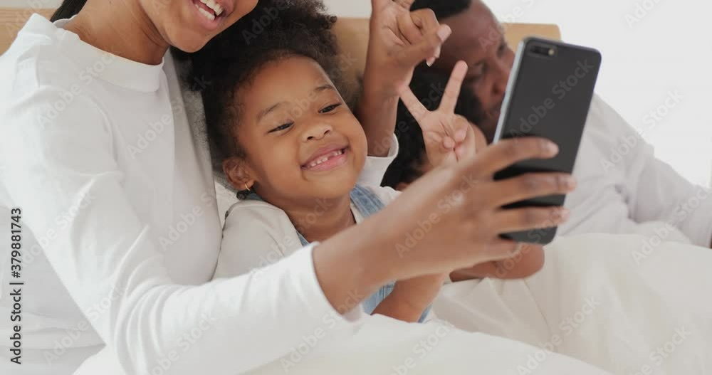 Portrait of family using smartphone to take photo together. Mother and daughter selfie together at bedroom. Portrait of family using smartphone to take photo together. Mother and daughter selfie together at bedroom.