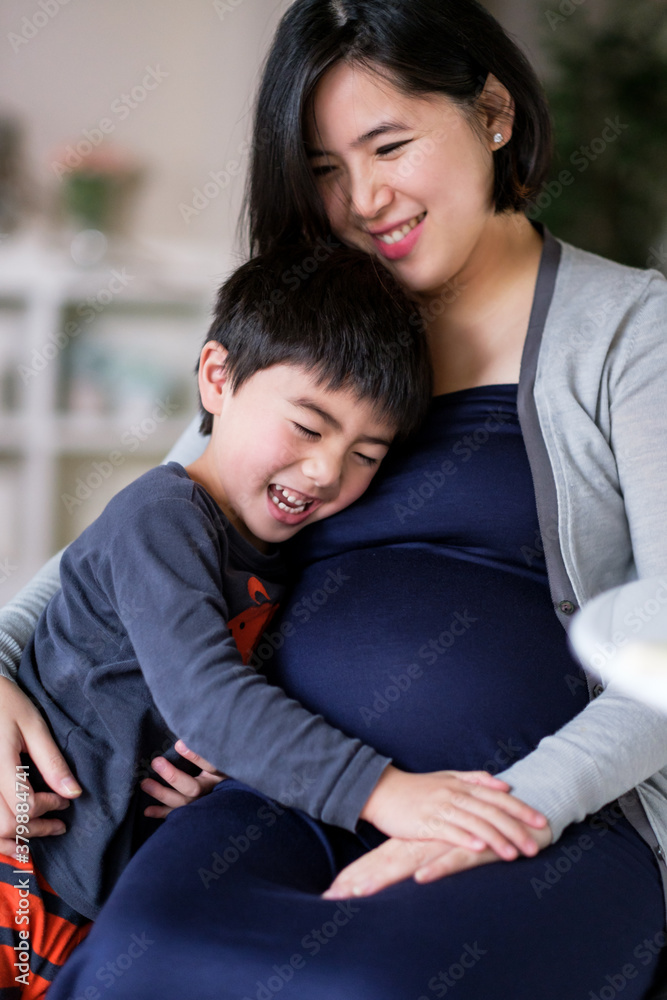 Pregnant Asian woman with her son at home Pregnant Asian woman with her son at home