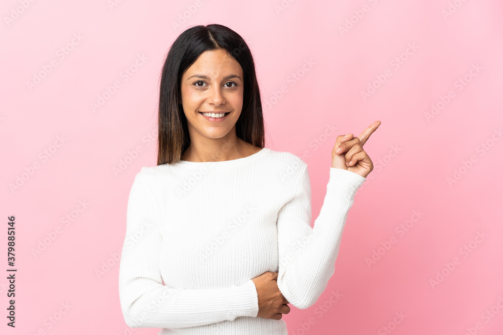 Caucasian girl isolated on pink background happy and pointing up Caucasian girl isolated on pink background happy and pointing up