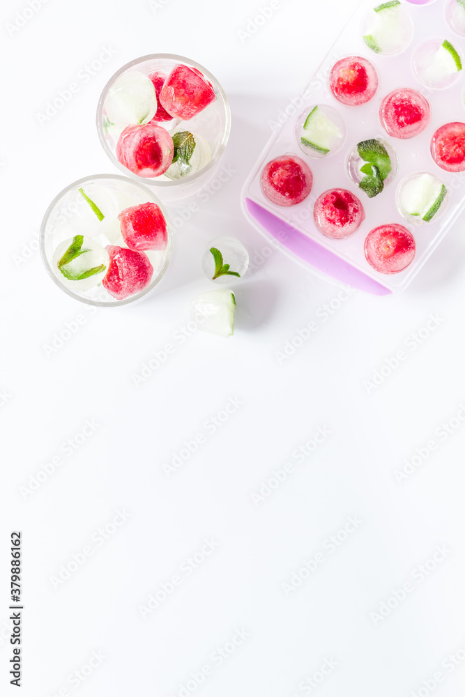 Raspberry and lime in ice cubes on white table top view copy space Raspberry and lime in ice cubes on white table top view copy space