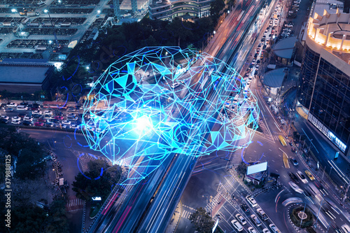 Brain hologram on aerial view of road, busy urban traffic highway at night. Junction network of transportation infrastructure. The concept of developing coding and high-tech in logistics.