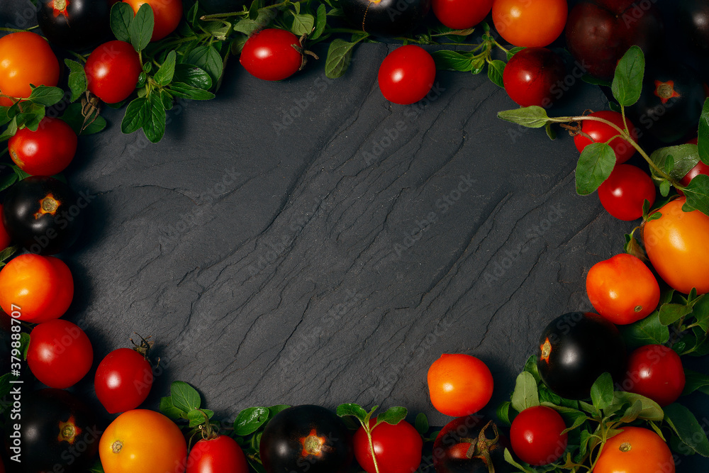 frame from vegetables, yellow, red and black cherry tomatoes, on a black background frame from vegetables, yellow, red and black cherry tomatoes, on a black background