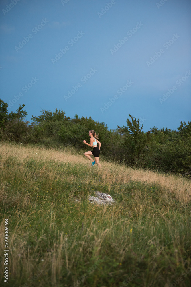 Young woman running on a green meadow in summer Young woman running on a green meadow in summer