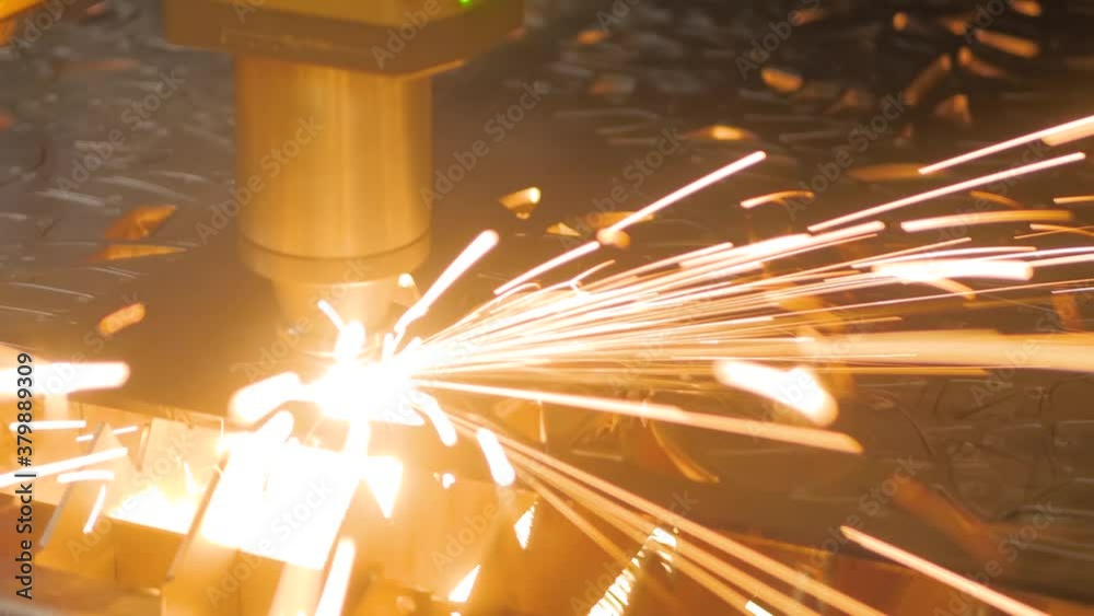 Metalworking, equipment, machining, industrial, technology, manufacturing concept. Automatic cnc laser cutting machine working with sheet metal with sparks at factory, plant - close up