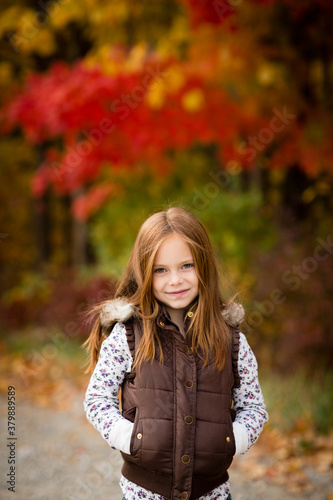 Portrait of Happy Girl with Red Hair During Autumn Outside