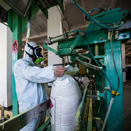 Photos Aktobe region/Kazakhstan - May 04 2012: Packing yellow sulphur in plastic bags on oil refinery plant