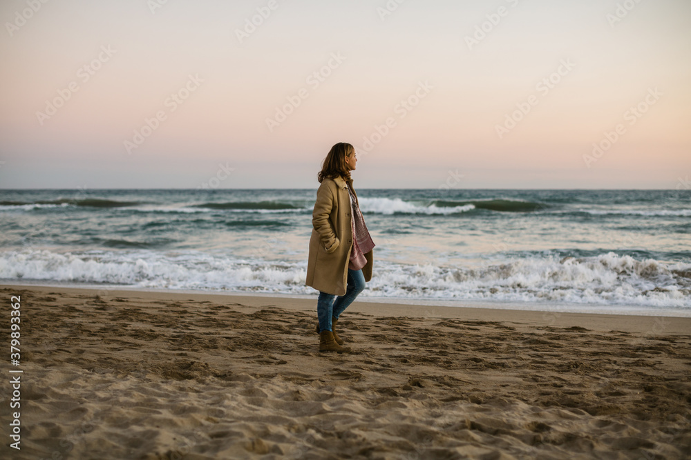 Woman relaxing walking on the beach in autumn.