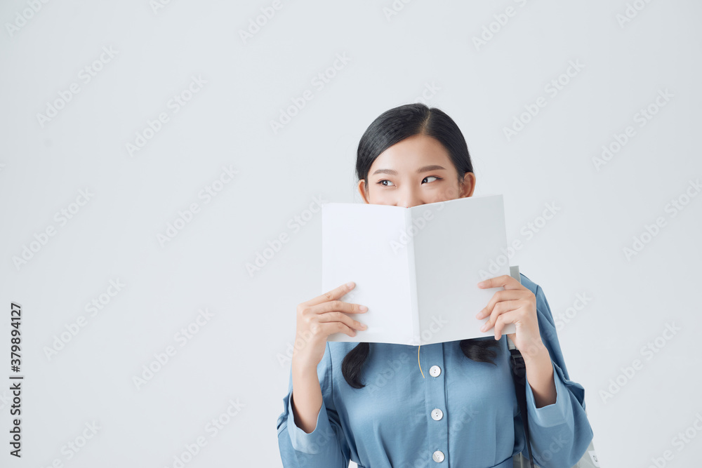 Joyful dark-haired girl covers her face with her white notebook Joyful dark-haired girl covers her face with her white notebook