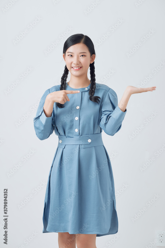 Young beautiful asian woman smiling cheerful presenting and pointing with palm of hand looking at the camera.