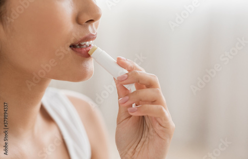 Cropped of asian woman using lipbalm  side view