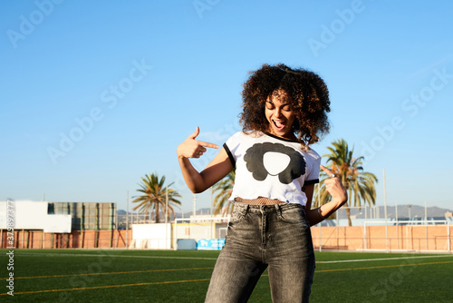 Beautiful girl pointing at her t-shirt with her silhouette photo