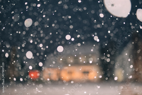 Snow falling outside of a suburban home at christmas
