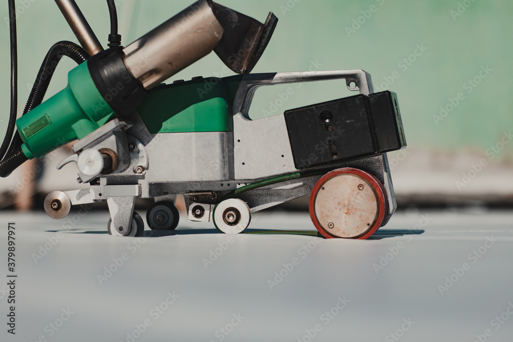 Automatic welder hot-air tools welds synthetic membranes on roof. Automatic welder hot-air tools welds synthetic membranes on roof.