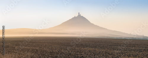 Castle Hazmburk. Ruins of Hazmburk castle on top of mountain peak of Ceske Stredohori range. Medieval castle with views on czech countryside landscape near Prague  in the morning mist, Czech Republic photo