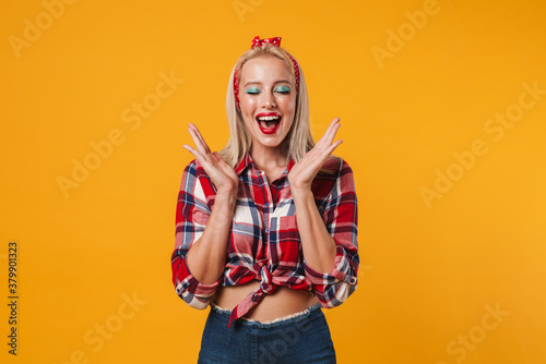 Image of excited blonde pinup girl posing and smiling at camera