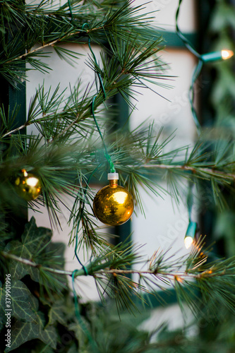 Golden balls and lights on spruce branches in garden