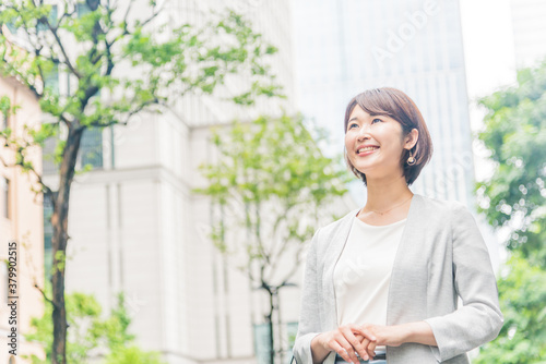 オフィス街で微笑む若い女性