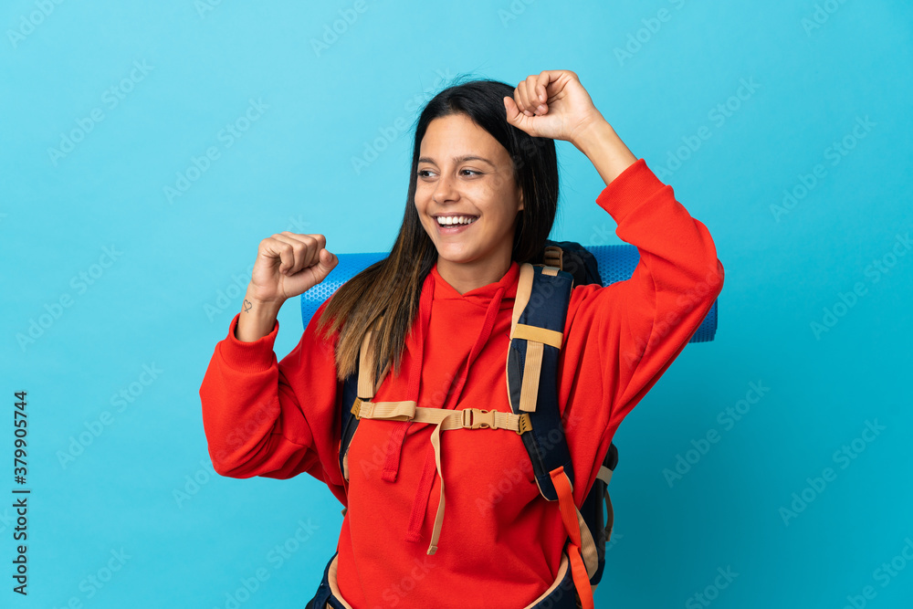 Young mountaineer woman with backpack celebrating a victory Young mountaineer woman with backpack celebrating a victory