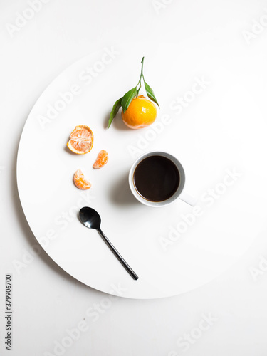 Satsumas, coffee on white table with black spoon photo