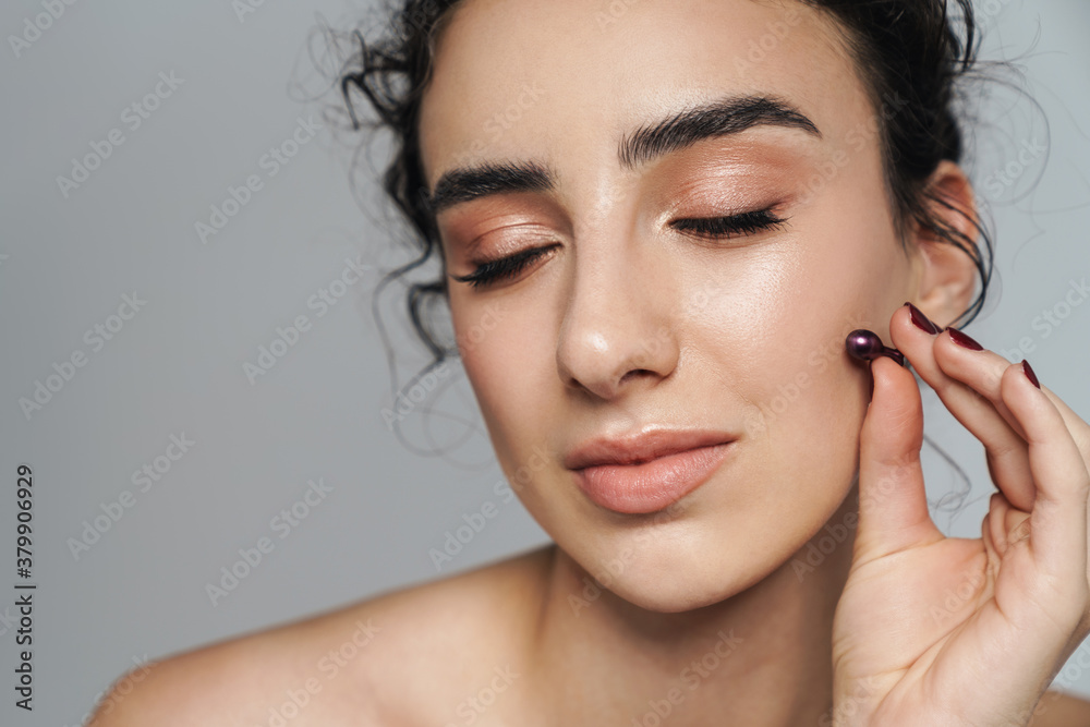 Image of half-naked woman posing with cosmetic vitamin capsule Image of half-naked woman posing with cosmetic vitamin capsule