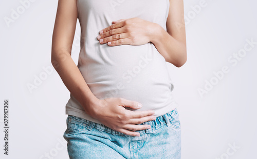 Pregnant woman holds hands on belly. Photo of pregnancy.
