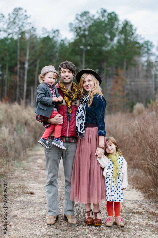 A beautiful family standing in the middle of a dirt road A beautiful family standing in the middle of a dirt road