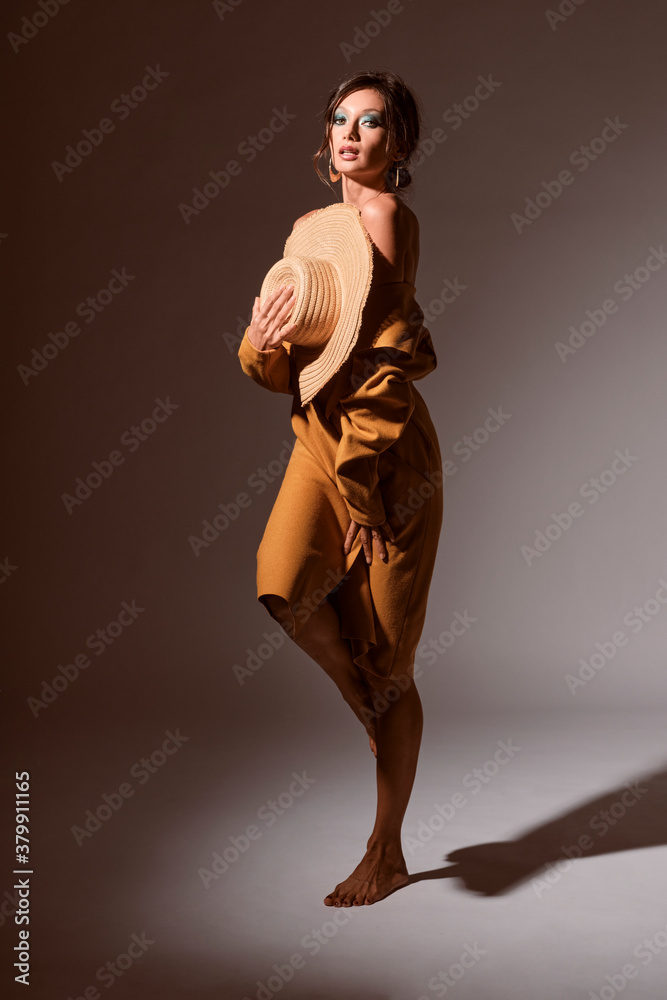 Sexy brunette young woman portrait standing wearing black lingerie and a yellow coat with a hat Sexy brunette young woman portrait standing wearing black lingerie and a yellow coat with a hat