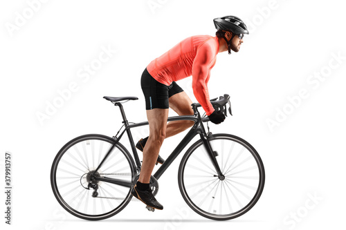 Cyclist with helmet and sunglasses riding a bicycle out of the saddle