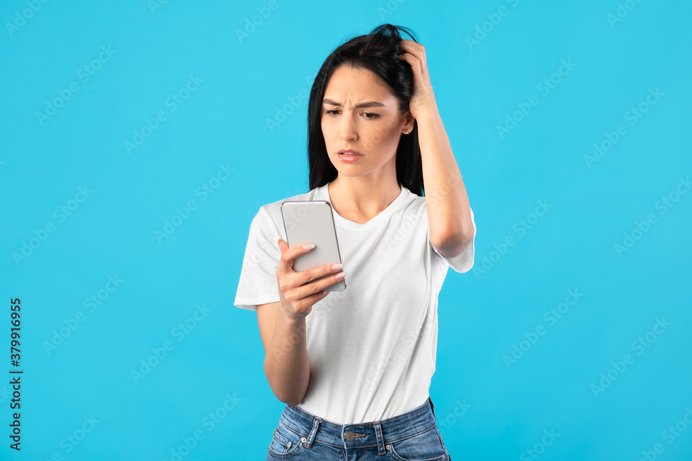 Confused upset young woman using mobile phone Confused upset young woman using mobile phone