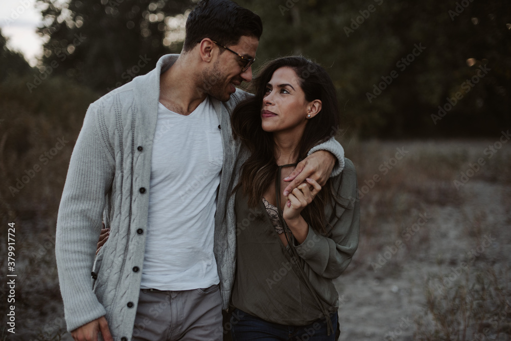 Young attractive couple hugging and laughing on the beach at dusk Young attractive couple hugging and laughing on the beach at dusk
