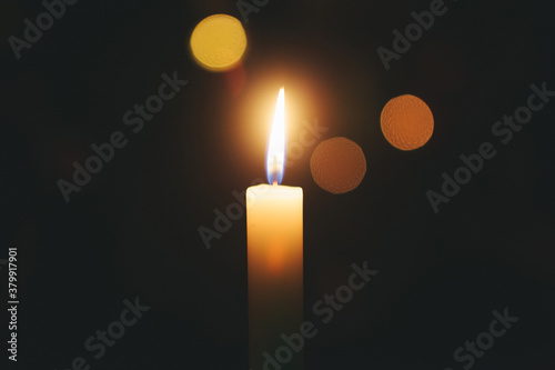 Single candle flame, black background photo