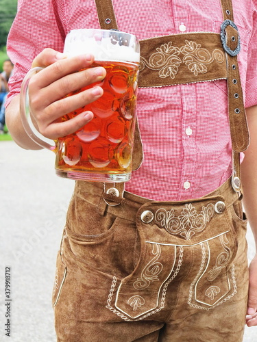 Man holding a glass of beer wearing German Bavarian clothes photo