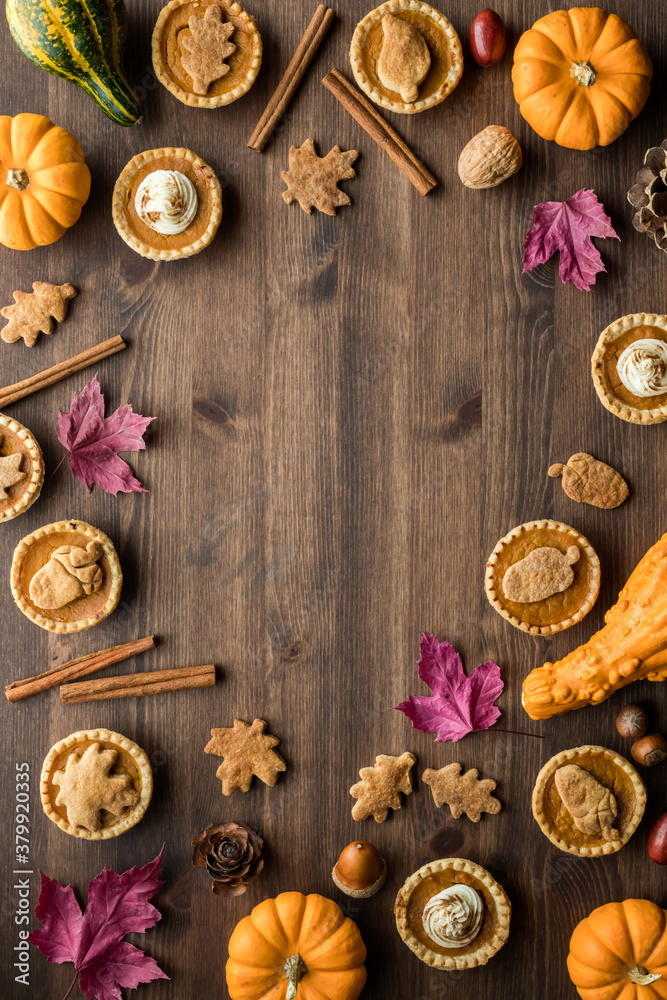 Top down view of various pumpkin pie tarts and fall decorations with copy space in the middle. Top down view of various pumpkin pie tarts and fall decorations with copy space in the middle.